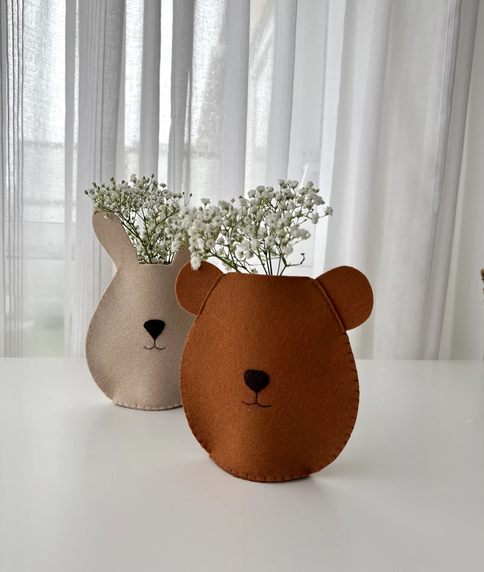 Two finished felt vase projects with flowers