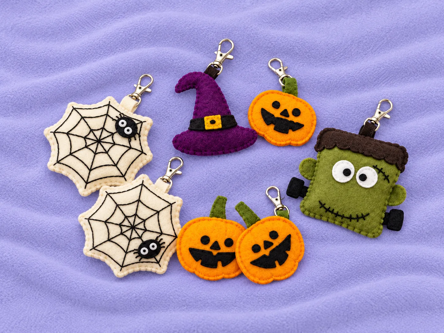 Handmade Halloween felt keychains with pumpkins, spiderwebs, a witch hat and a friendly monster